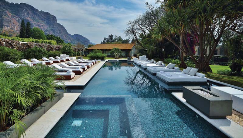 Piscina de Amomoxtli con tumbonas y el Tepozteco al fondo